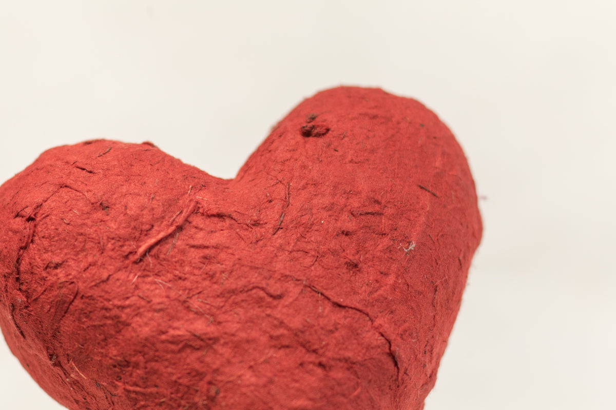 Red heart-shaped Elephant POOPOOPAPER eco-friendly ornament close-up for rustic texture